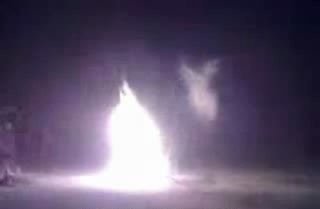 This image is from a video that allegedly shows an angel or celestial being flying or "dancing" around a campfire.